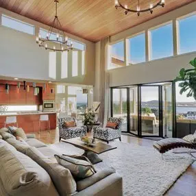 Open plan living room with large bay windows and folding doors