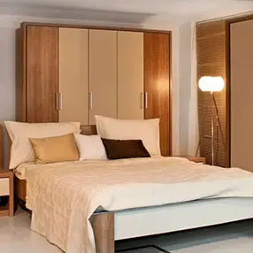 Cream and brown bed with large wardrobes