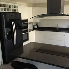 Black and white kitchen with black fridge