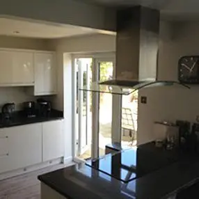 Black and white kitchen with open doors to garden