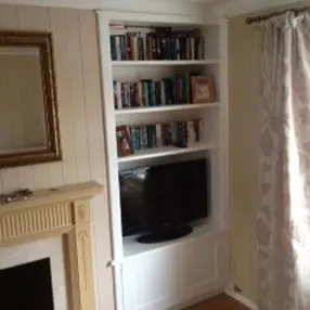 Fitted white shelving unit and cupboard